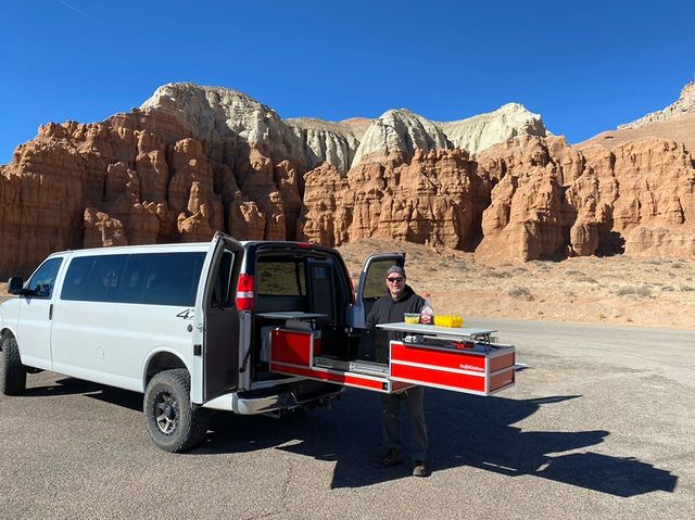 Van Life: Slide out camping kitchen mounted in van, man cooking lunch with scenic view of Canyonlands